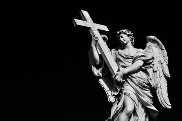 Wall Mural - Angel statue holding Holy Cross. A 17th century baroque masterpiece at the top of Sant'Angelo Bridge in the center of Rome (Black and White with copy space)