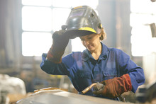 Waist Up Portrait Of Smiling Woman Welding Metal While Working At Industrial Plant, Copy Space
