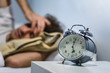© Mego-studio - Young latin man sleeping with alarm clock.