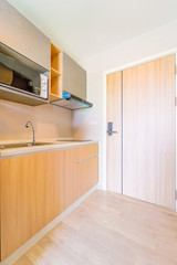 Wall Mural - Looking into a small empty kitchen with stove, fridge and cupboards