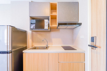 Wall Mural - Looking into a small empty kitchen with stove, fridge and cupboards