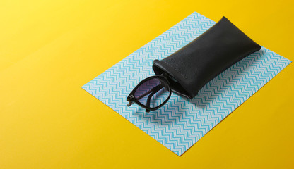 Fashionable sunglasses in a protective case on paper background.