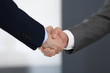 © rogerphoto - Business people shaking hands at meeting or negotiation in modern office, close-up. Teamwork, partnership and handshake concept