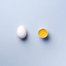Food Concept With Broken Egg And Whole One On Grey Background. Top View. Creative Pattern In Minimal Style. Flat Lay. Square Crop