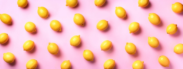 Wall Mural - food pattern with lemons on pink paper background. top view. summer concept. vegan and vegetarian di