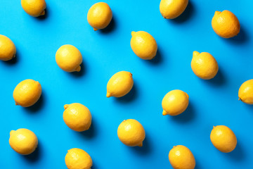 Wall Mural - food pattern with lemons on blue paper background. top view. summer concept. vegan and vegetarian di