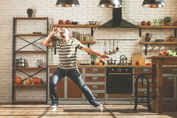 Handsome mature man having fun in kitchen