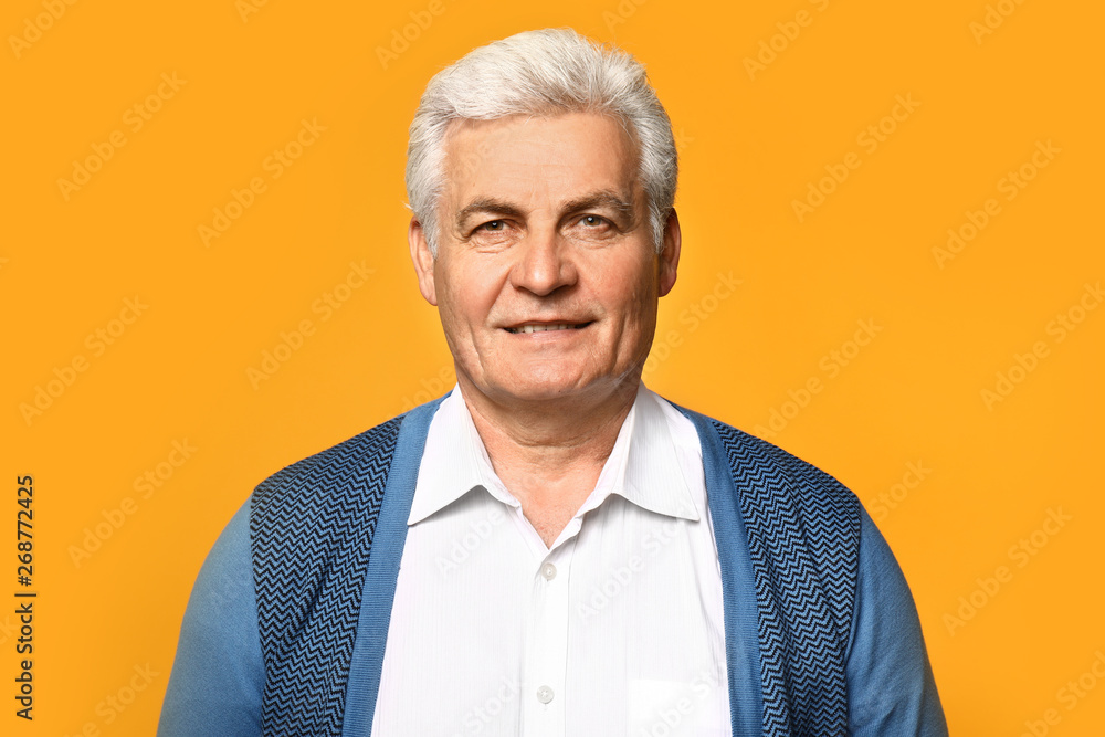 Portrait of handsome senior man on color background