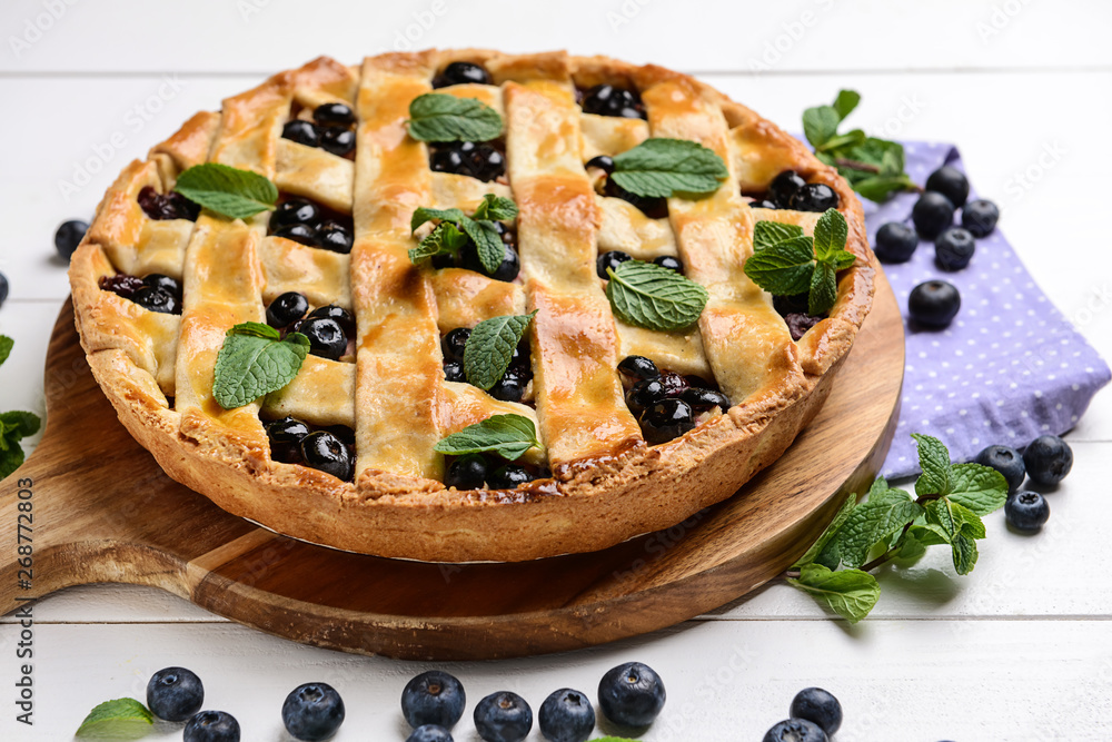Tasty blueberry pie on white wooden table