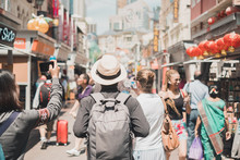 Young Man Hipster Traveling With Backpack And Hat, Happy Solo Traveler Walking At Chinatown Street Market In Singapore. Landmark And Popular For Tourist Attractions. Southeast Asia Travel Concept