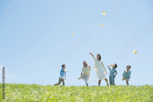 草原で紙飛行機を飛ばす小学生と先生 Adobe Stock でこのストック画像を購入して 類似の画像をさらに検索 Adobe Stock