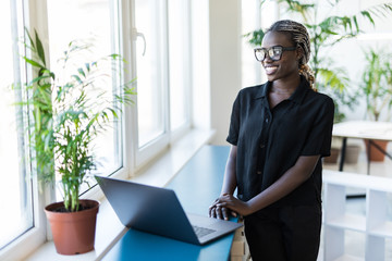 Close up portrait of a beautiful young woman smiling and looking at laptop screen