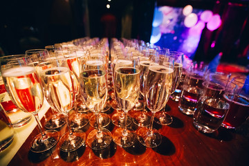 Wall Mural - full glass of champagne in a nightclub. Many glasses of champagne on the bar. bubbles of champagne in a glass.