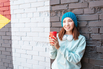 Wall Mural - Trendy girl teenager hipster with disposable Cup made of paper. Ecology and drinks concept