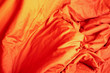Red cloth. Crumpled bedding. Background. Texture. Soft focus.