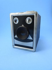 Old classic nostalgic box camera on a blue background