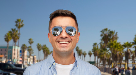 Poster - summer holidays, vacation and emotions concept - face of smiling middle aged latin man in shirt and sunglasses over venice beach background in california