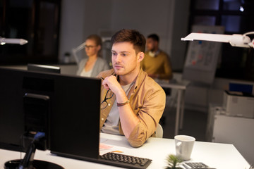 business, deadline and technology concept - man with computer working at night office