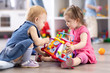 © Oksana Kuzmina - Babies conflict in nursery. Child girl trying to take away toy from another kid.