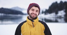 Portrait Of Smiling Large Man In Front Of The Camera , In The Middle Of Landscape With Amazing Background Of Lake And Snowy Forest And Mountain, He Have A Red Nose And Charismatic Face