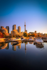 Wall Mural - View of harbor in a yacht club at Toronto city during sunset with Canadian tower as background