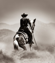 Cowboy On A Horse Running In Desert