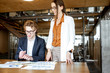 © rh2010 - Young business man and woman working on documents at the wooden table in the office or coworking space