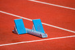 © Augustas Cetkauskas - Athletic start block on dark red tartan track