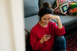 © ZHPH Production/Stocksy - Young woman interact with her smartphone while drink coffee in the living room