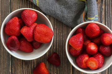 Strawberries on a white cutting board on a wooden background