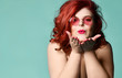 Plus-size overweight redhead lady in sunglasses send a kiss at free text copy space on mint