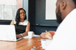 © Gerald Carter/Creative Flame - Businesswoman smiles at coworker in meeting