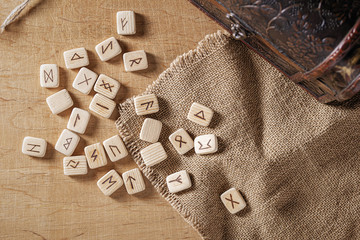 Wall Mural - Handmade scandinavian wooden runes on a wooden vintage background. Concept of fortune telling and prediction of the future.