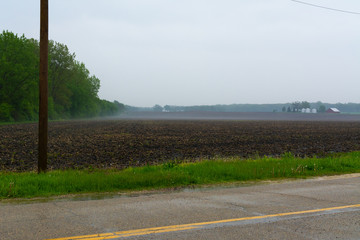 Road and field in the rain