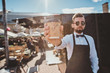 © Fxquadro - Modern groomed barista in sunglasses has a break and enjoying coffee. There are bright sunny summer day.