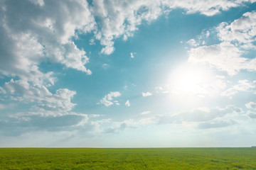 Sunny cloudscape under the green field