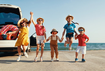 Wall Mural - group happy children girls and boys friends   on   car ride to summer trip.