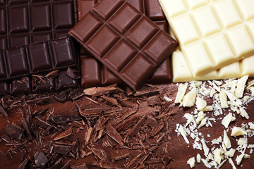 Wall Mural - chocolate in diffrent color. milk, dark and white chocolate bars on table