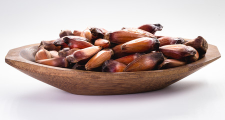 Brazilian pine in brown wooden rustic bowl. Typical araucaria tree seed used as a condiment in Brazilian cuisine in winter.