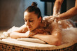 Pretty dark haired female having relaxing massage with foam in a wellness spa turkish hammam.