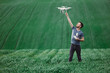 Young man piloting a drone on a spring field