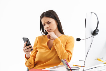 Sticker - Portrait of serious customer supporter woman holding smartphone while working in call center