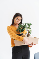 Sticker - Full length portrait of frustrated young woman dressed in elegant wear holding box with office supplies due to firing