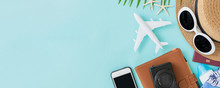 Top View Of Traveler Accessories, Tropical Palm Leaf And Airplane On Blue Background With Empty Space For Text. Travel Summer Holiday Vacation Banner Concept.