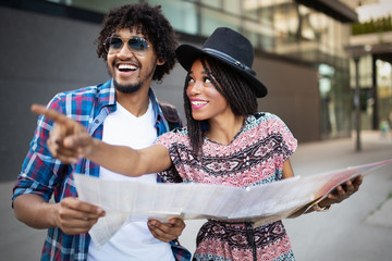 Happy couple on vacation sightseeing city with map