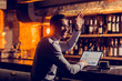 © Viacheslav Yakobchuk - Freelancer sitting at the bar stand with laptop waving his friend