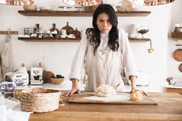 Sticker - Portrait of irritated european woman making homemade pasta of dough in kitchen at home