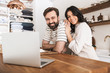 © Drobot Dean - Portrait of happy couple looking at laptop while cooking pastry in kitchen at home