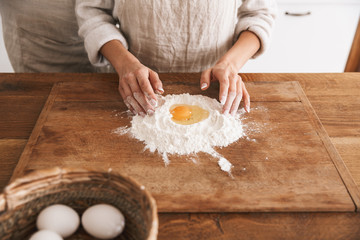 Sticker - Portrait of attractive couple wearing aprons cooking pastry with flour and eggs in kitchen at home