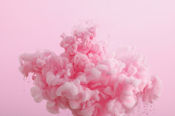 close up view of pink smoky paint in water isolated on pink